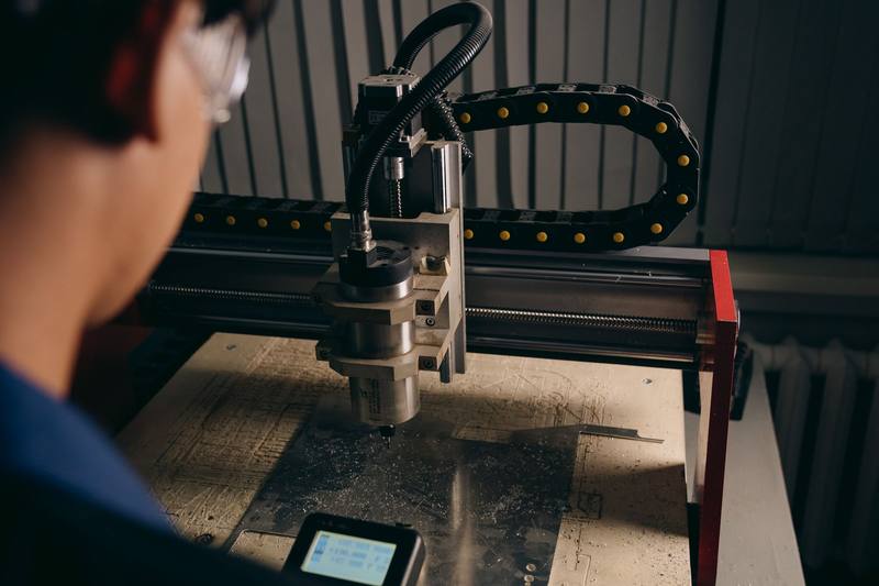 CNC machine cutting a part with a technician nearby